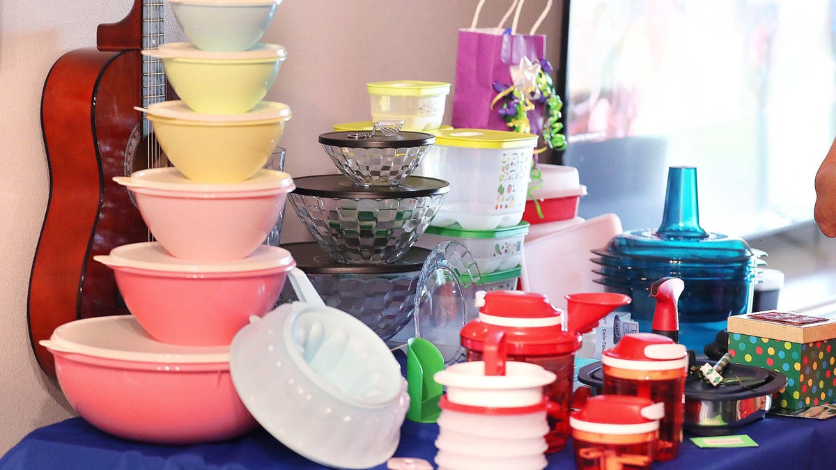 Articles Tupperware, y compris un ensemble de "rétro" contenants de stockage, posés sur une table lors d'une soirée Tupperware.