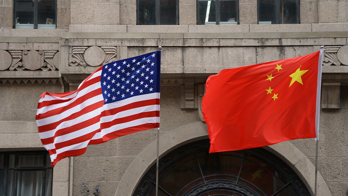 The national flags of the United States and China flutter at the Fairmont Peace Hotel on April 25, 2024, in Shanghai.