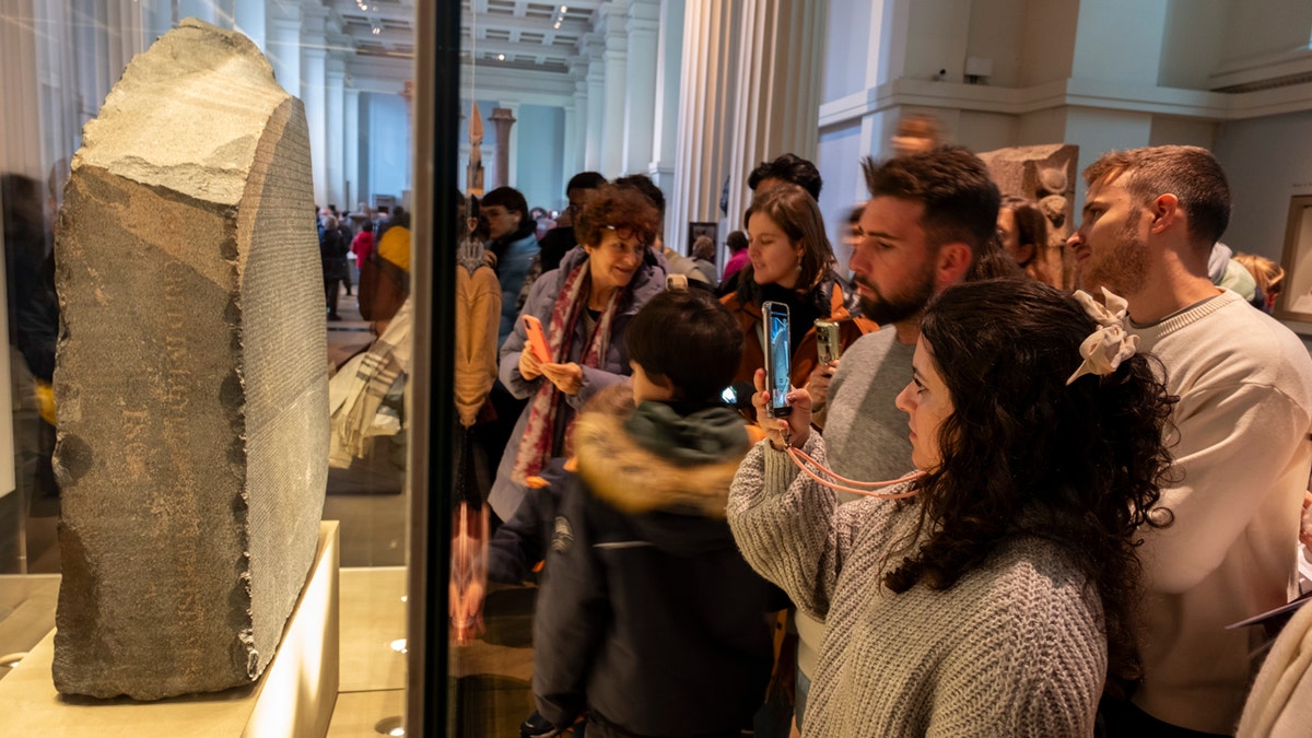 Visitors to the British Museum looking at the Rosetta Stone