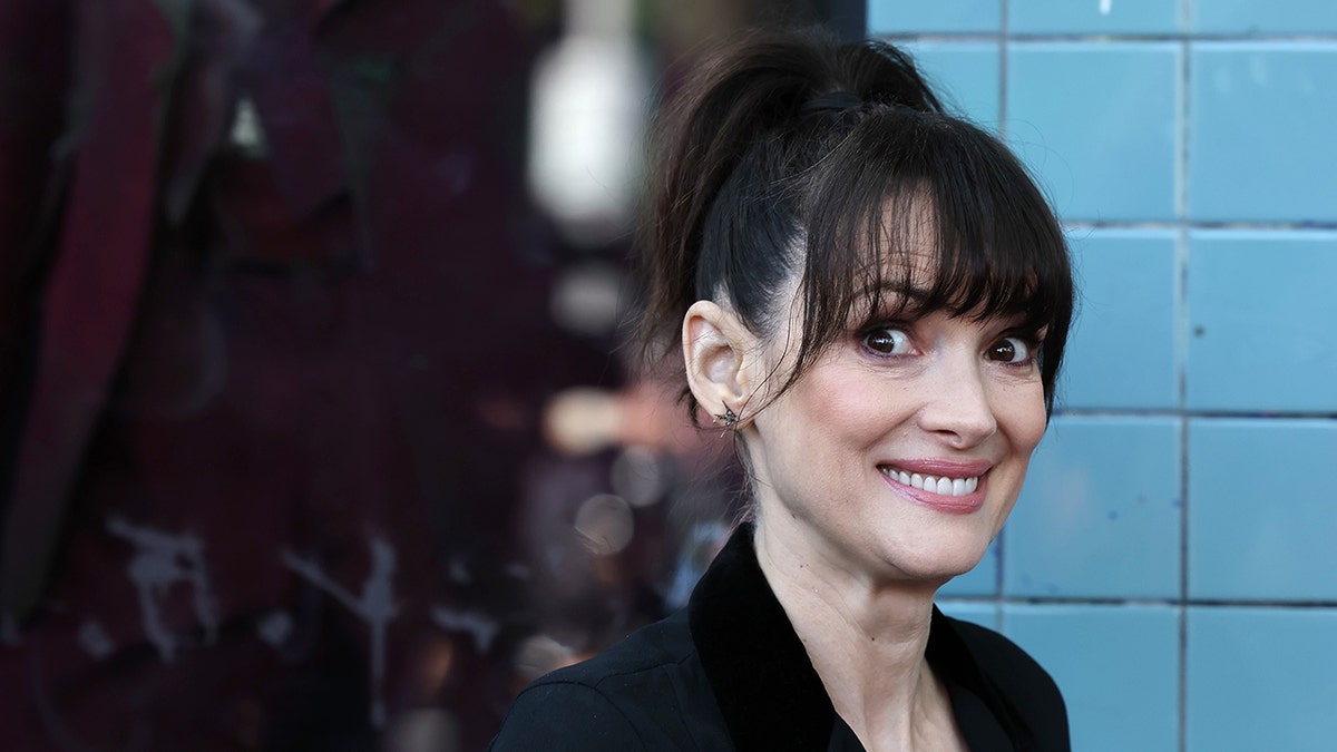 Winona Ryder grins and looks bright eyed at a Walk of Fame Ceremony for Tim Burton