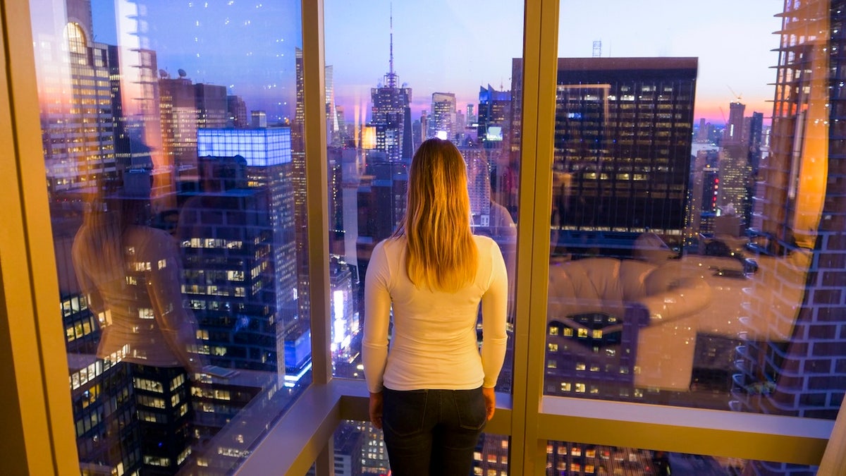 Mujer en la ventana luces de la ciudad