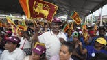 Supporters of president and independent presidential candidate Ranil Wickremesinghe wave national flags during a election public rally in Minuwangoda, Sri Lanka, Tuesday, Sept. 17, 2024.