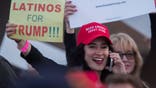 A woman hoods a sign expressing Latino support for Republican presidential candidate Donald Trump at his campaign rally at the Orange County Fair and Event Center, April 28, 2016, in Costa Mesa, California. - Trump is vying for votes in the June 7 California primary election in hope of narrowing the gap to the 1,237 delegates needed to win the Republican presidential nomination. (Photo by DAVID MCNEW / AFP) (Photo by DAVID MCNEW/AFP via Getty Images)