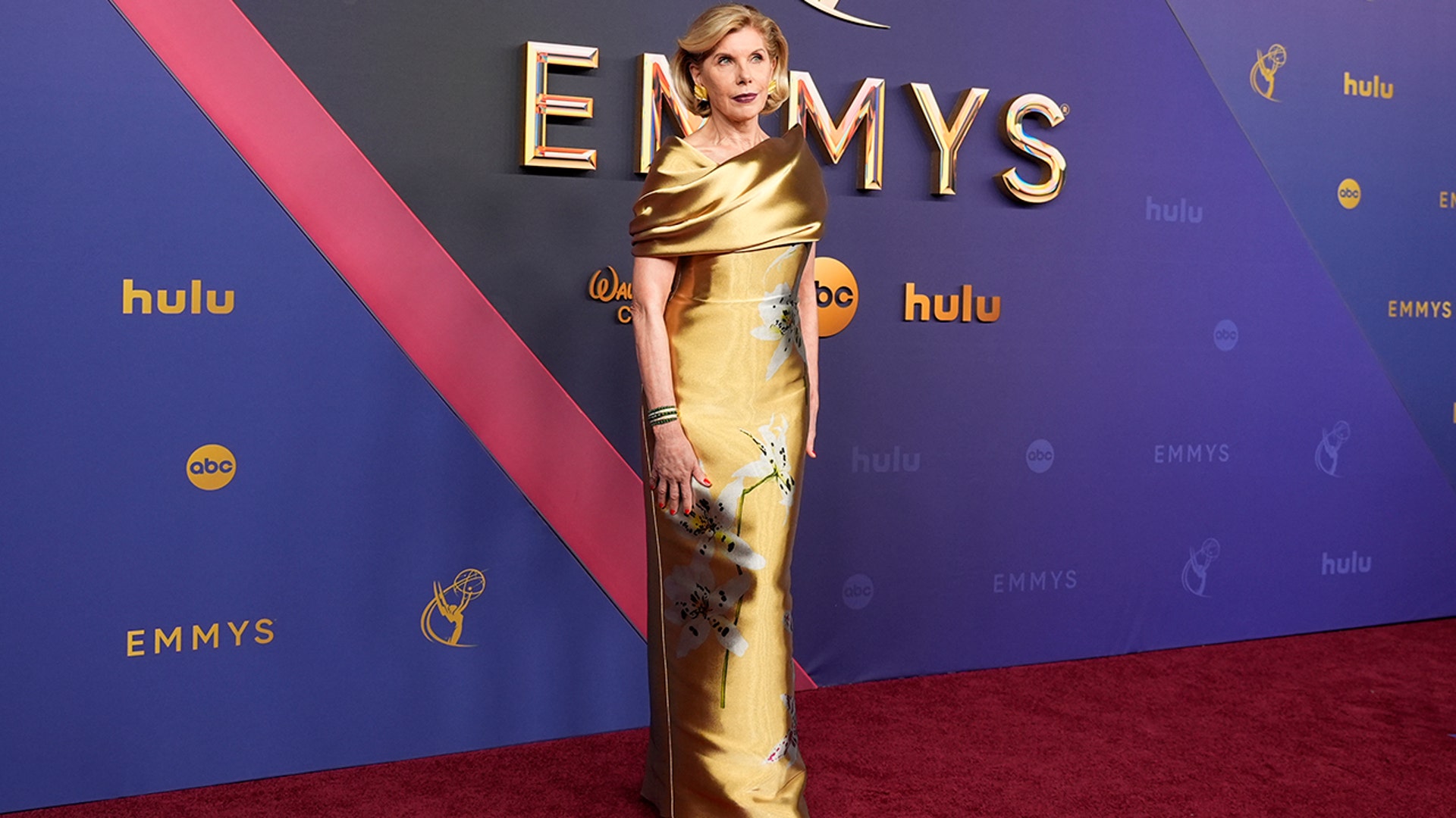 Christine Baranksi, nominated for her role in "The Gilded Age," in a gold gown on the red carpet at the 2024 Emmy Awards.