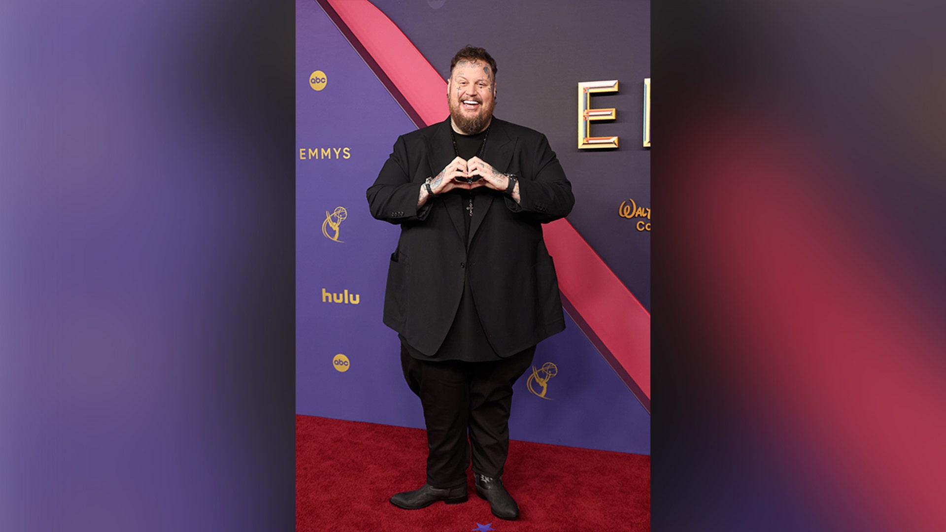 Jelly Roll on the 2024 Emmy Awards red carpet in a black suit.