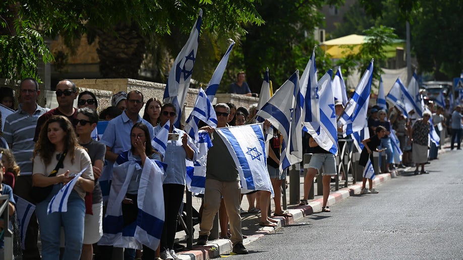 Israelis wave flags along Goldberg-Polin's funeral procession