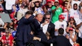Former President Trump is assisted by U.S. Secret Service personnel after gunfire rang out during a campaign rally at the Butler Farm Show in Butler, Pennsylvania, on July 13. - Fox News