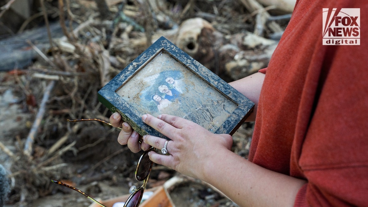 Mekenzie Craig brushes mud off her wedding photos of surviving the mudslide that killed her husband on Sept. 9, 27.
