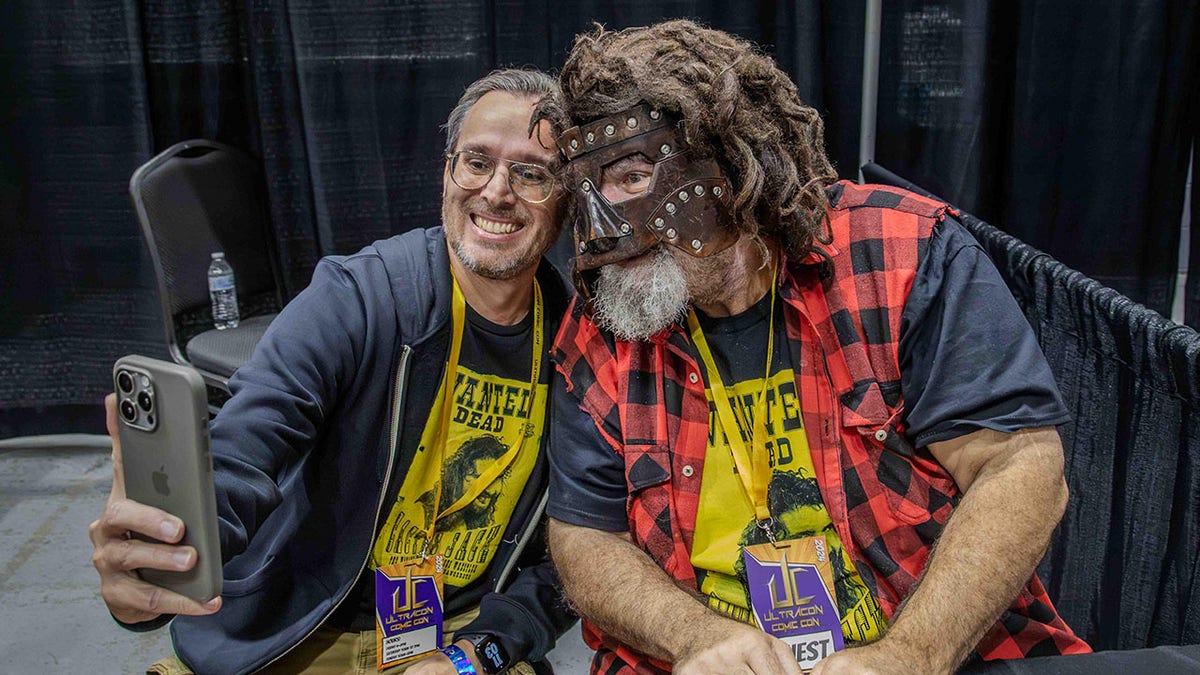 Mick Foley poses pinch fan