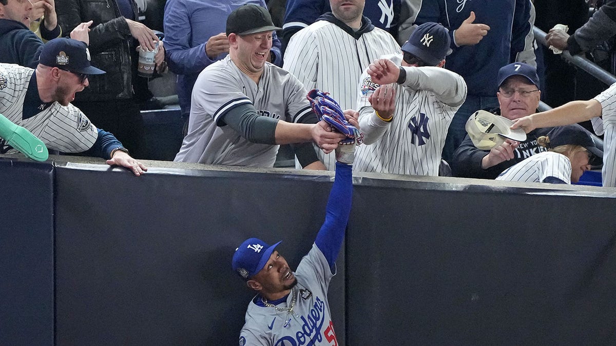 Fans pull the ball out of Mookie Betts' glove