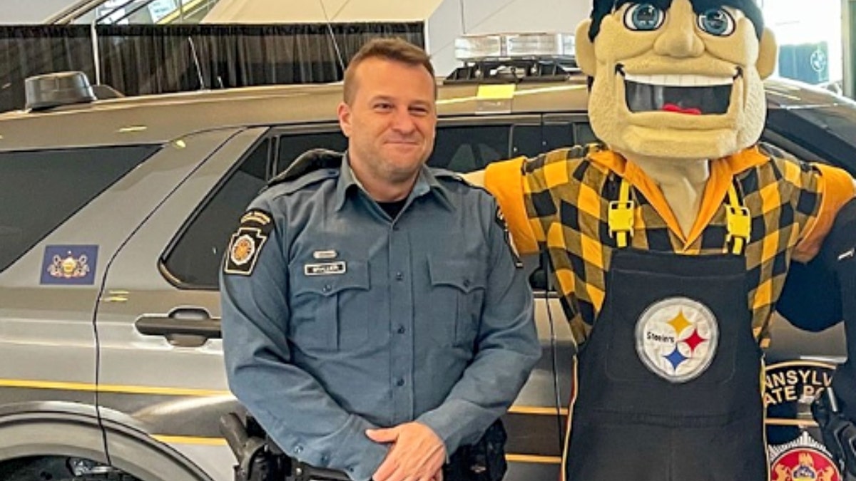 Benjamin Brallier stands adjacent  to a Pittsburgh Steelers mascot