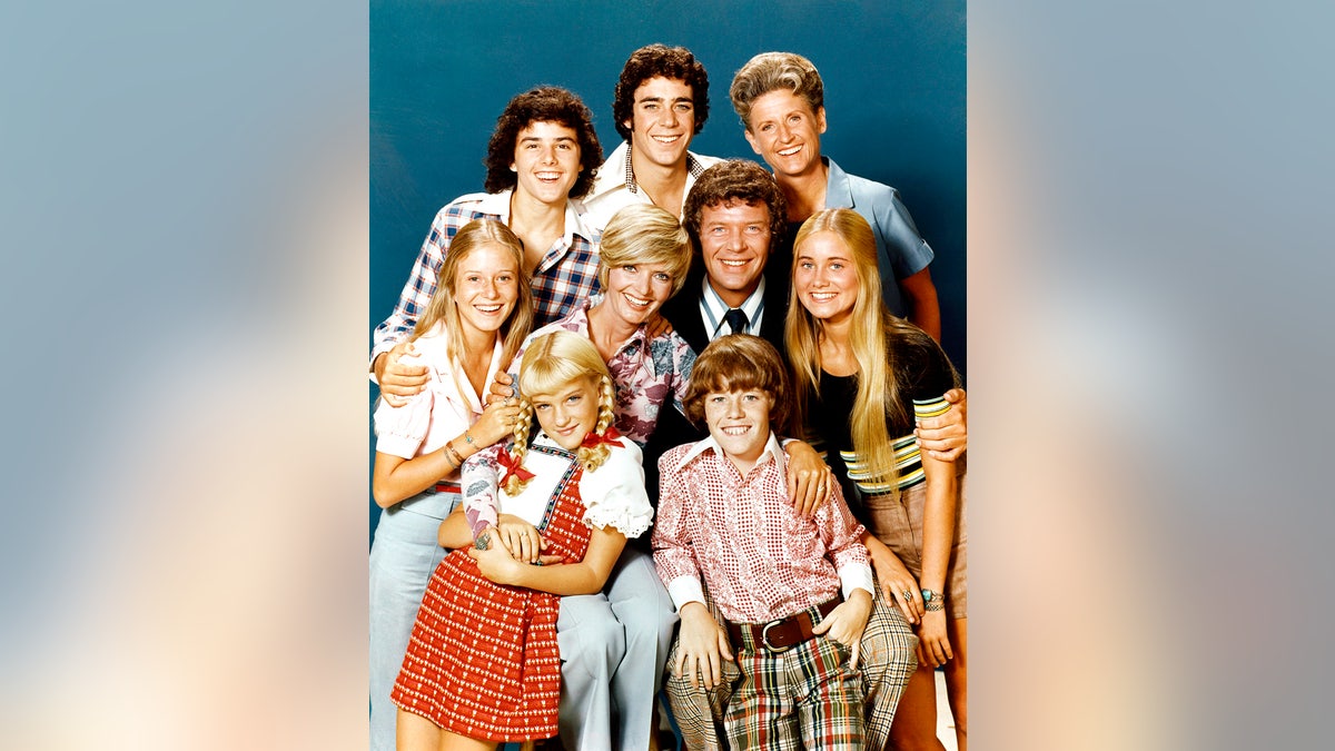 The cast of “The Brady Bunch” poses together.