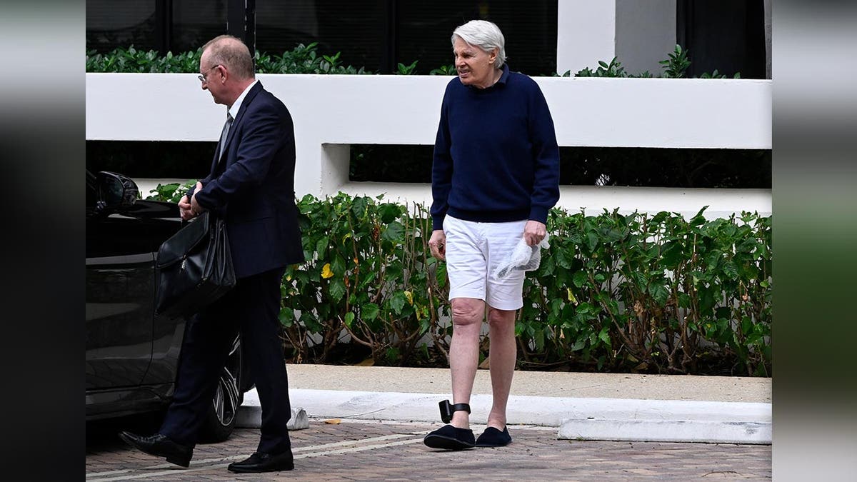 An ankle show fitted to nan limb of erstwhile Abercrombie and Fitch CEO Mike Jeffries is visible arsenic he walks distant from an agency building.