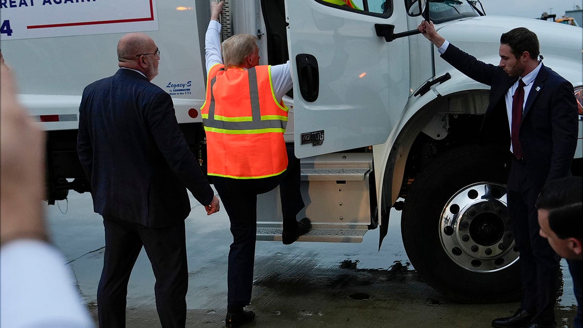 Trump getting on a garbage truck.