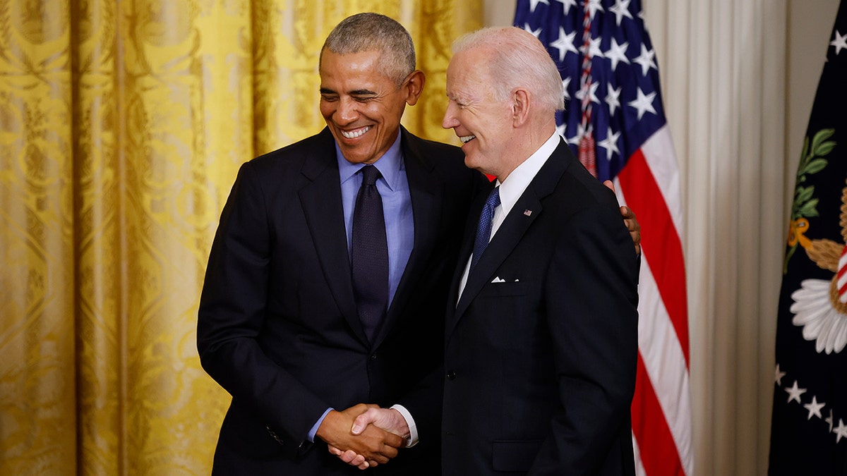 Obama and Biden shake hands at the White House in 2022