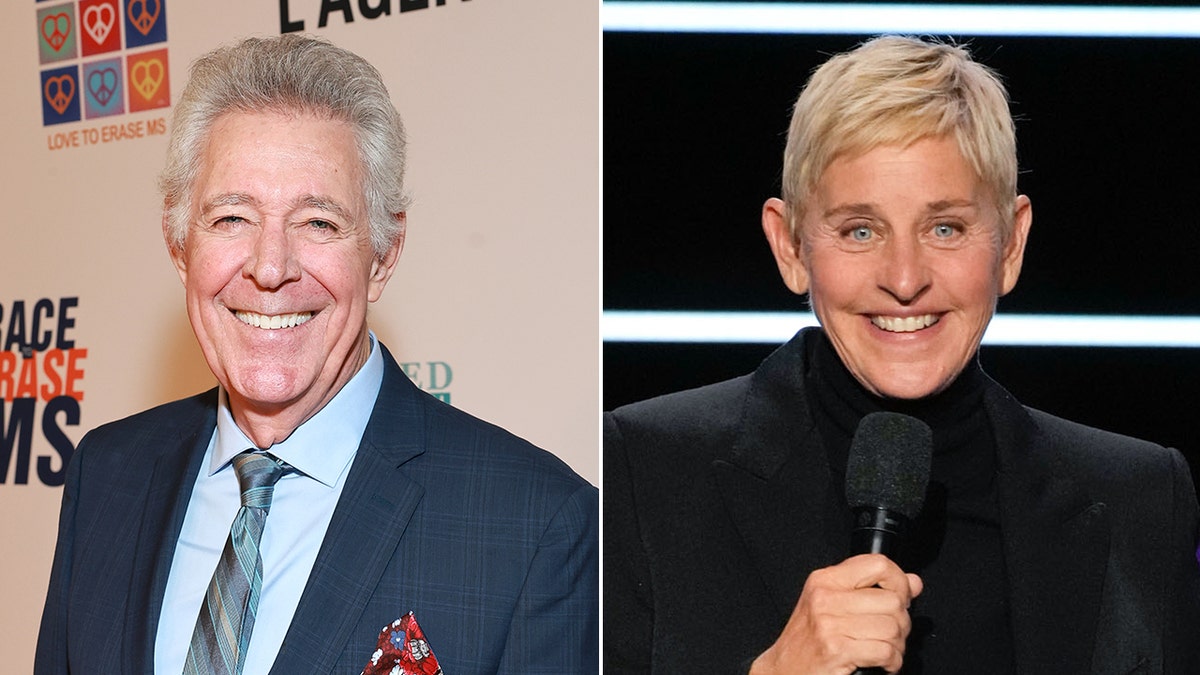 Barry Williams in a navy suit and sky blue shirt smiles on the carpet split Ellen Degeneres in a black suit smiles while holding a microphone