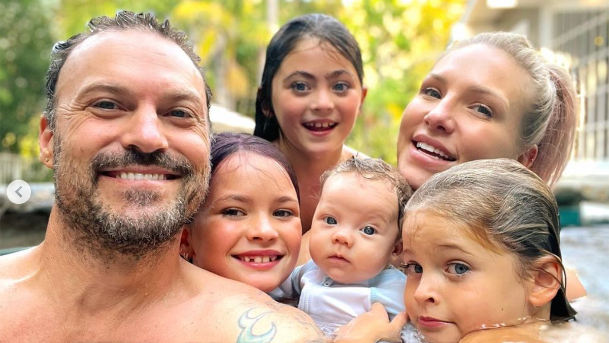 Brian Austin Green takes a selfie in a pool with four of his sons and Sharna Burgess