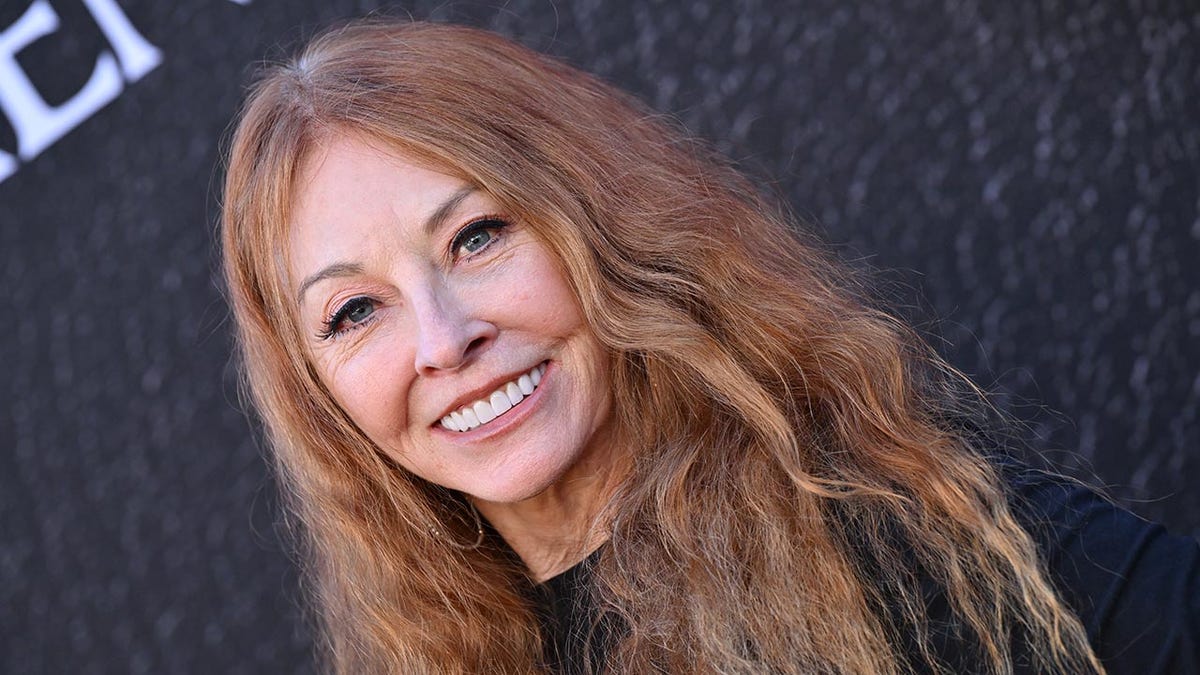 Cassandra Peterson as herself smiling on the carpet.