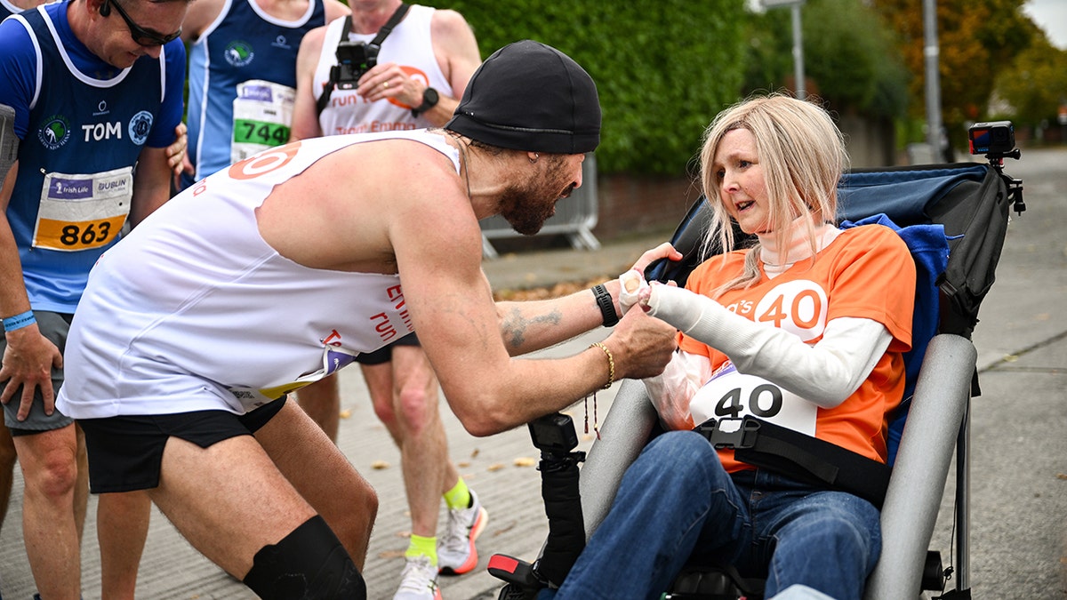 Colin Farrell wears achromatic  vessel  apical  and shorts to tally  marathon with Emma Fogarty.