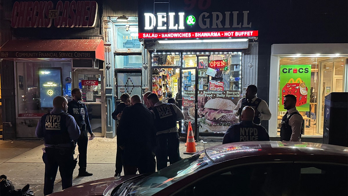 Police stand in front of a deli