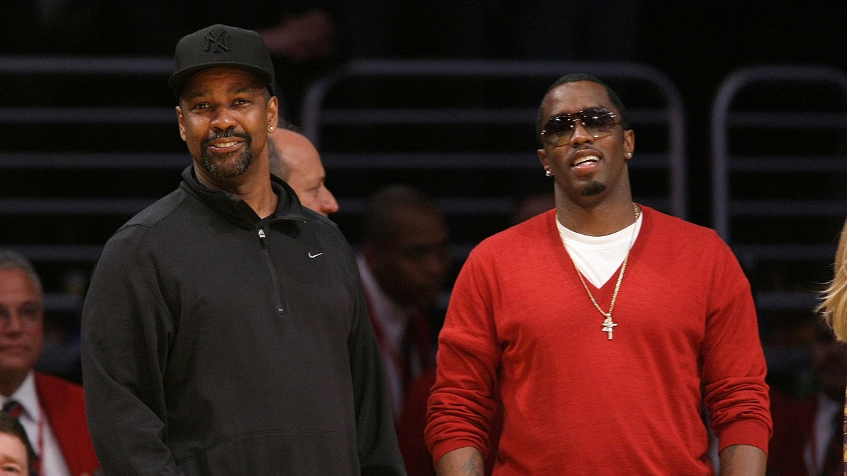 Sean Diddy Combs wears a red jersey with Denzel Washington during a basketball game.