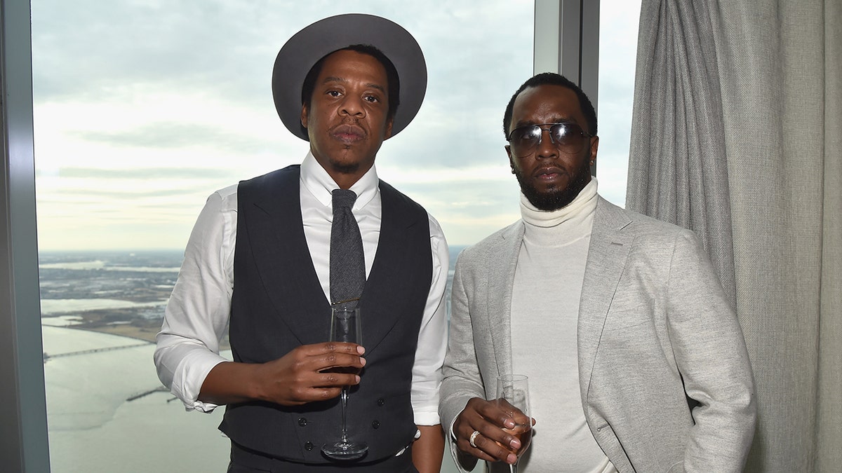 Los raperos Jay-Z y Diddy lucen conjuntos grises en una fiesta