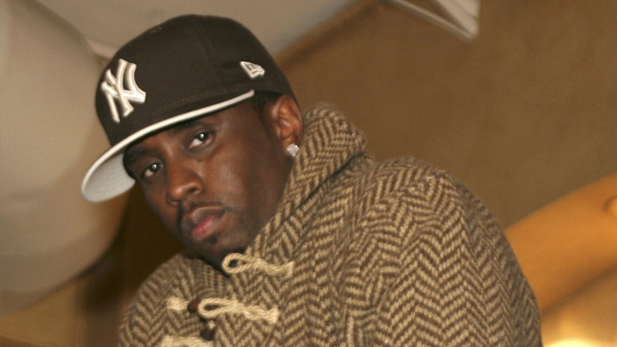 Sean Diddy Combs wears a achromatic  New York Yankees chapeau  and brownish  coat