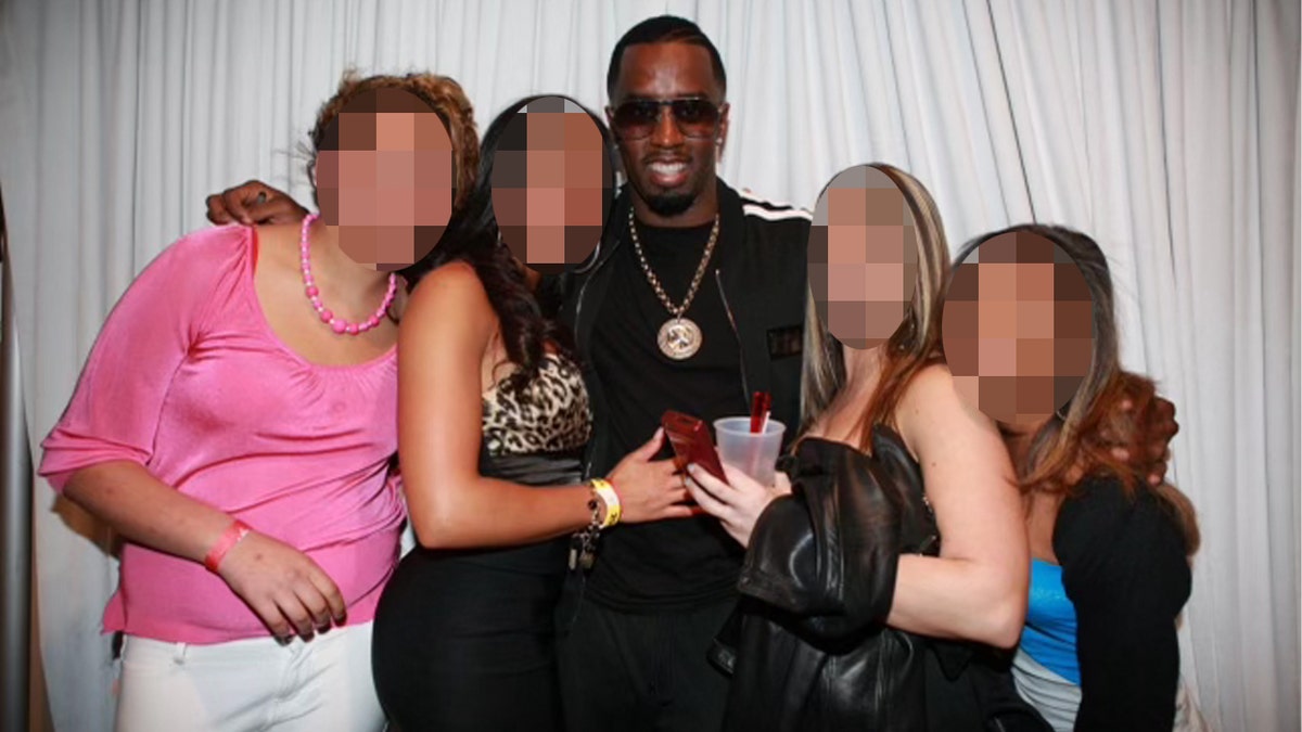 Sean 'Diddy' Combs posa con un grupo de mujeres delante de una cortina blanca