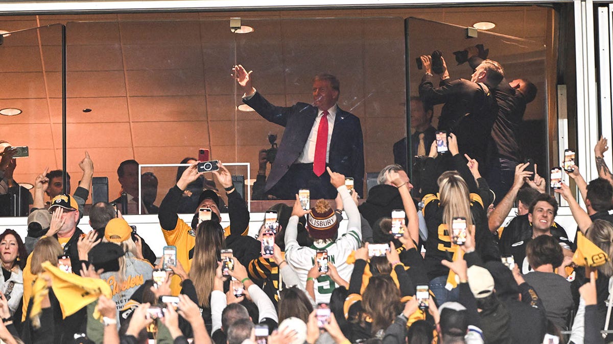 Donald Trump waves to the crowd at the Steelers game