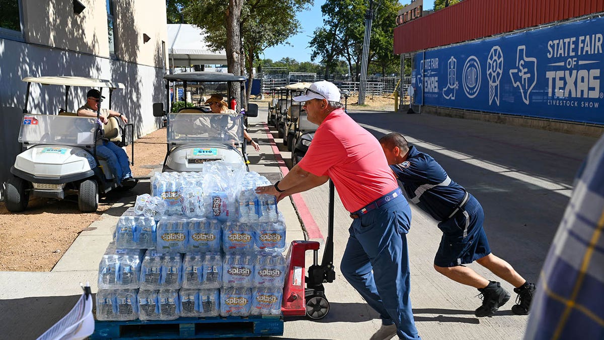 Person pushing crates of drinks.