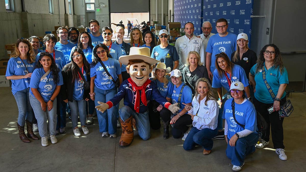 "Little Big Tex" poses with those who volunteered at the State Fair Cares Food Drive.