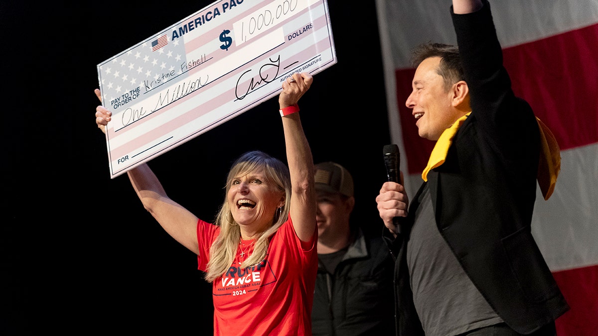 Elon Musk with woman holding giant $1 million check