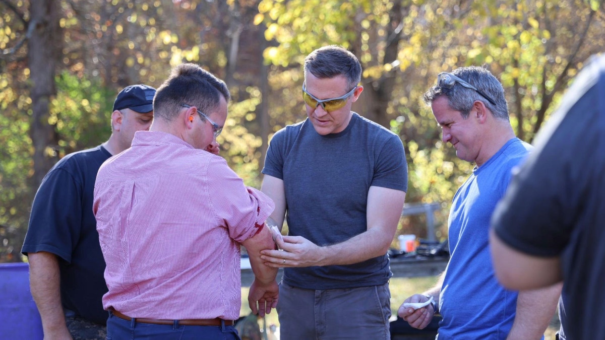 Lucas Kunce helping thin   to wounded newsman  deed  with shrapnel 