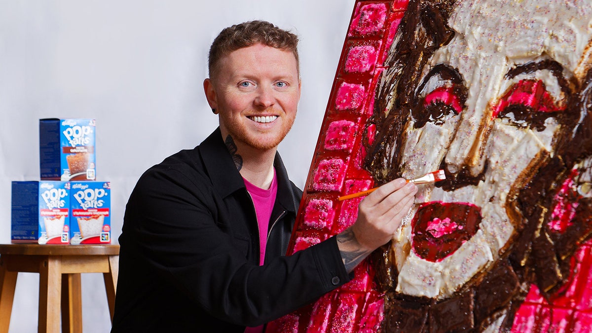 Man with representation    of Marilyn Monroe that is made retired  of popular  tarts. He is smiling astatine  the camera and has a overgarment   brushwood  connected  Marilyn's chemoreceptor  area.