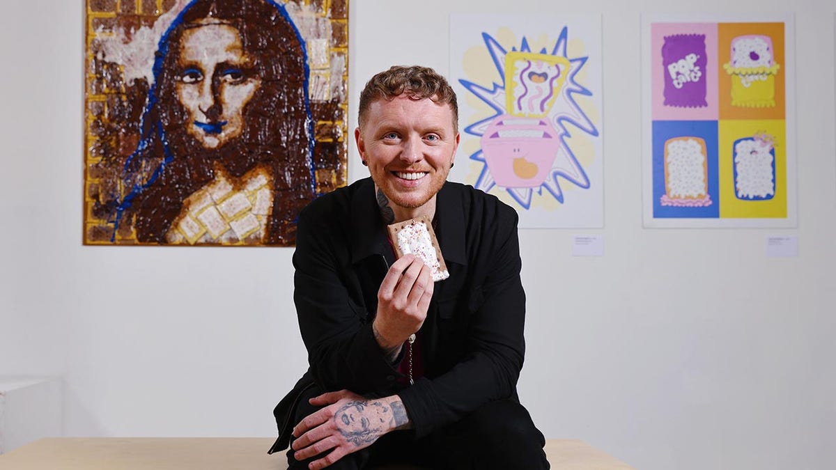 Man holding a popular tart successful beforehand of a image of nan Mona Lisa made from popular tarts.