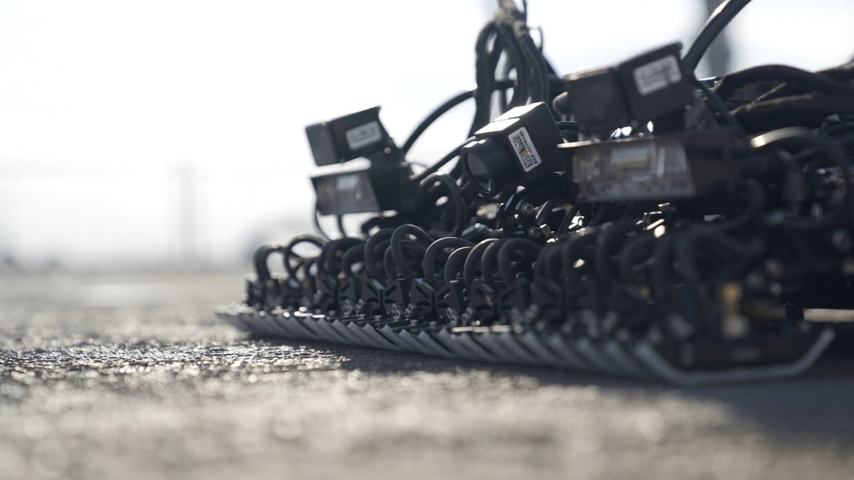 Close-up van een Gecko Robotics-eenheid terwijl deze over een Carrier-dek kruipt.