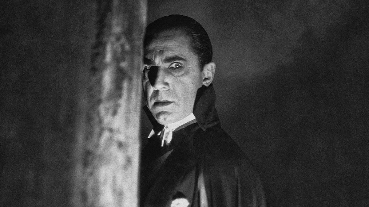 A close-up of Bela Lugosi looking to the side like Dracula.