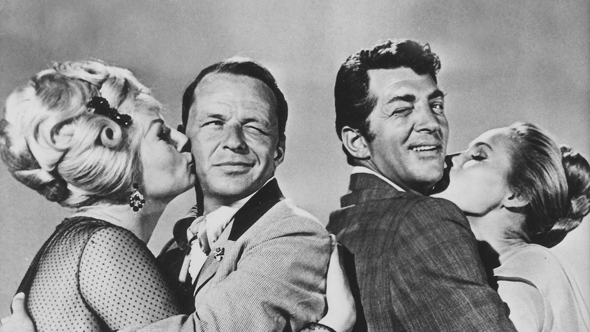 Frank Sinatra and Dean Martin getting kissed by two women.