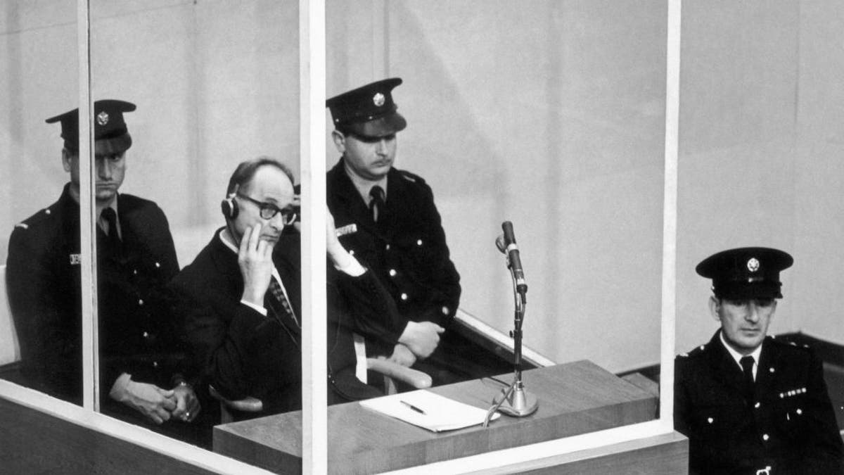 Adolf Eichmann, successful  a bullet-proof cabin, puts connected  earphones to perceive  the speechmaking  of the enactment  of accusation against him connected  Dec. 17, 1961.