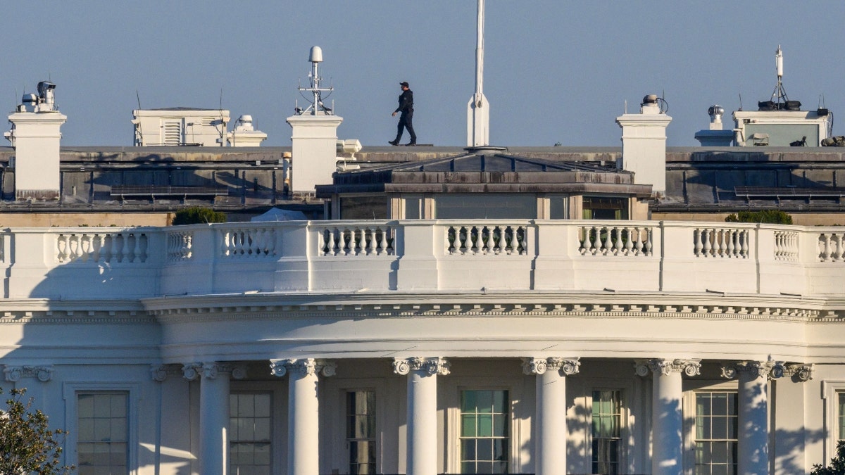 A member of the Secret Service Uniformed Division walks above the South Portico and South Lawn of the White House in Washington, DC on November 18, 2022.