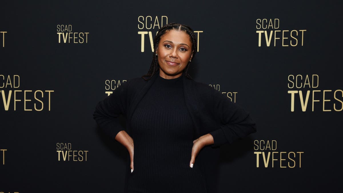  Toks Olagundoye posing connected reddish carpet