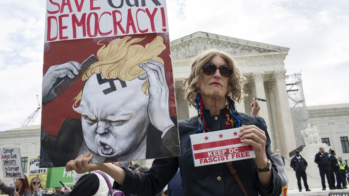 An activist holding a sign reading Save Our Democracy stands in front of the US Supreme Court, as the court prepares to hear arguments over former President Donald Trump's immunity in Washington, DC. (Photo by Probal Rashid/LightRocket via Getty Images)