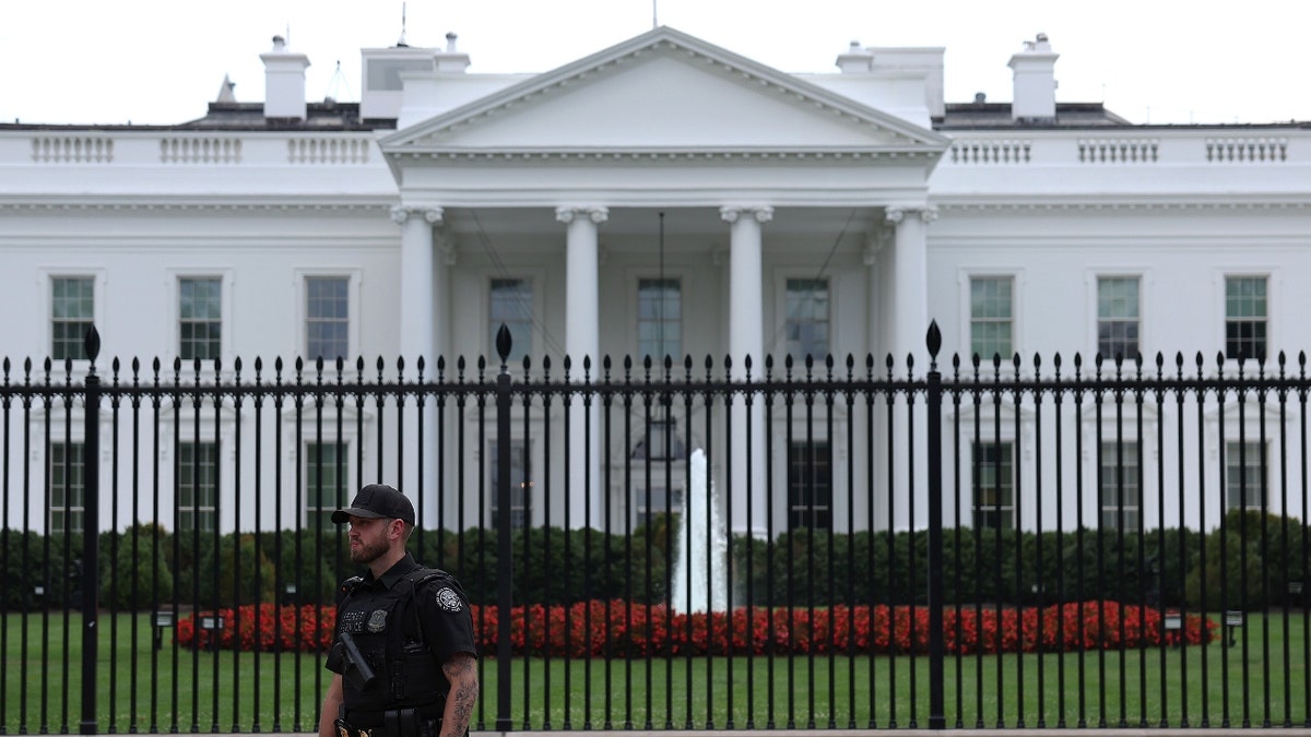 Een geüniformeerde agent van de geheime dienst houdt de wacht nadat de Amerikaanse president Joe Biden had aangekondigd dat hij zich had teruggetrokken uit de race voor herverkiezing, buiten het Witte Huis op 21 juli 2024 in Washington, DC.