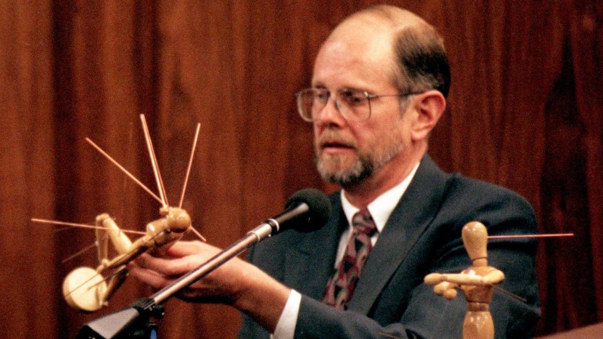 Dr. Robert Lawrence of Stockton, California, holds a mannequin illustrating Kitty Menendez's gunshot wounds during the Menendez brothers' 1995 murder trial.