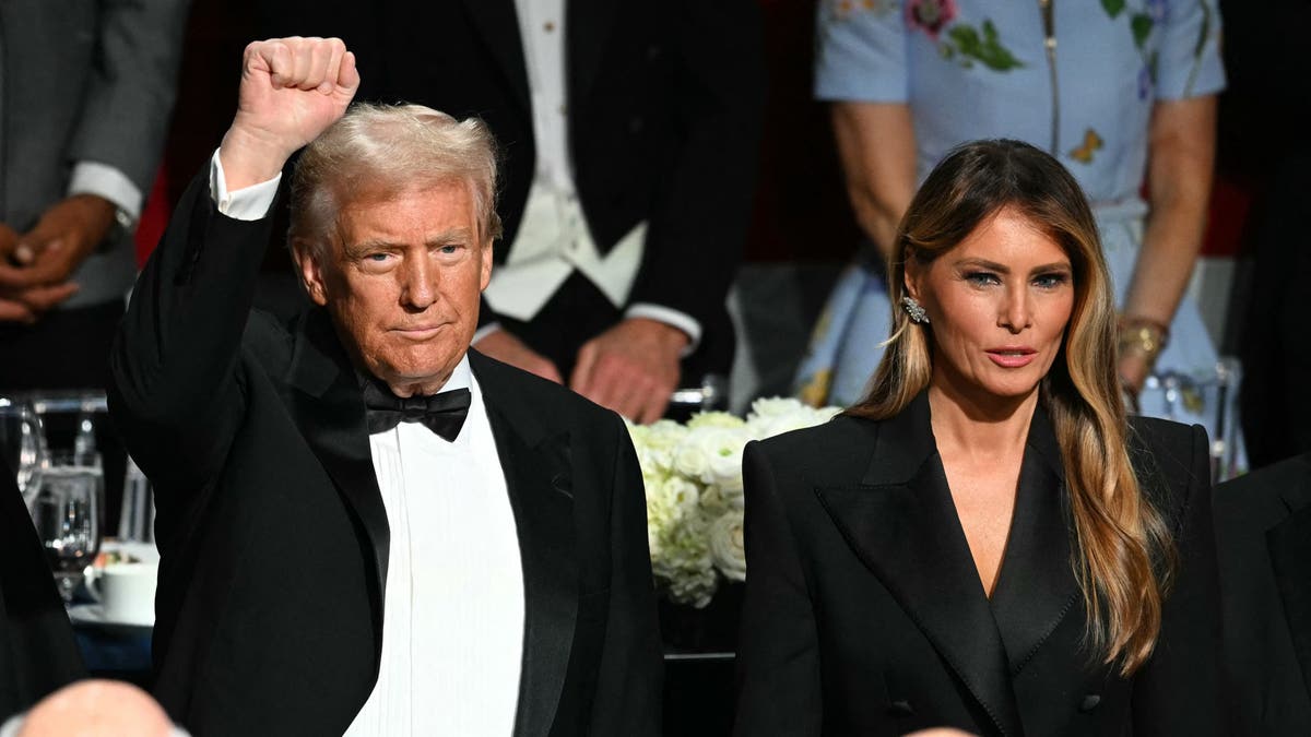 Mantan Presiden AS dan calon presiden dari Partai Republik Donald Trump mengacungkan tinjunya saat ia dan istrinya Melania Trump menghadiri Makan Malam Tahunan Alfred E. Smith Memorial Foundation ke-79 di Hilton Midtown di New York, 17 Oktober 2024. (Foto oleh Timothy A. CLARY / AFP) (Foto oleh TIMOTHY A. CLARY/AFP via Getty Images)