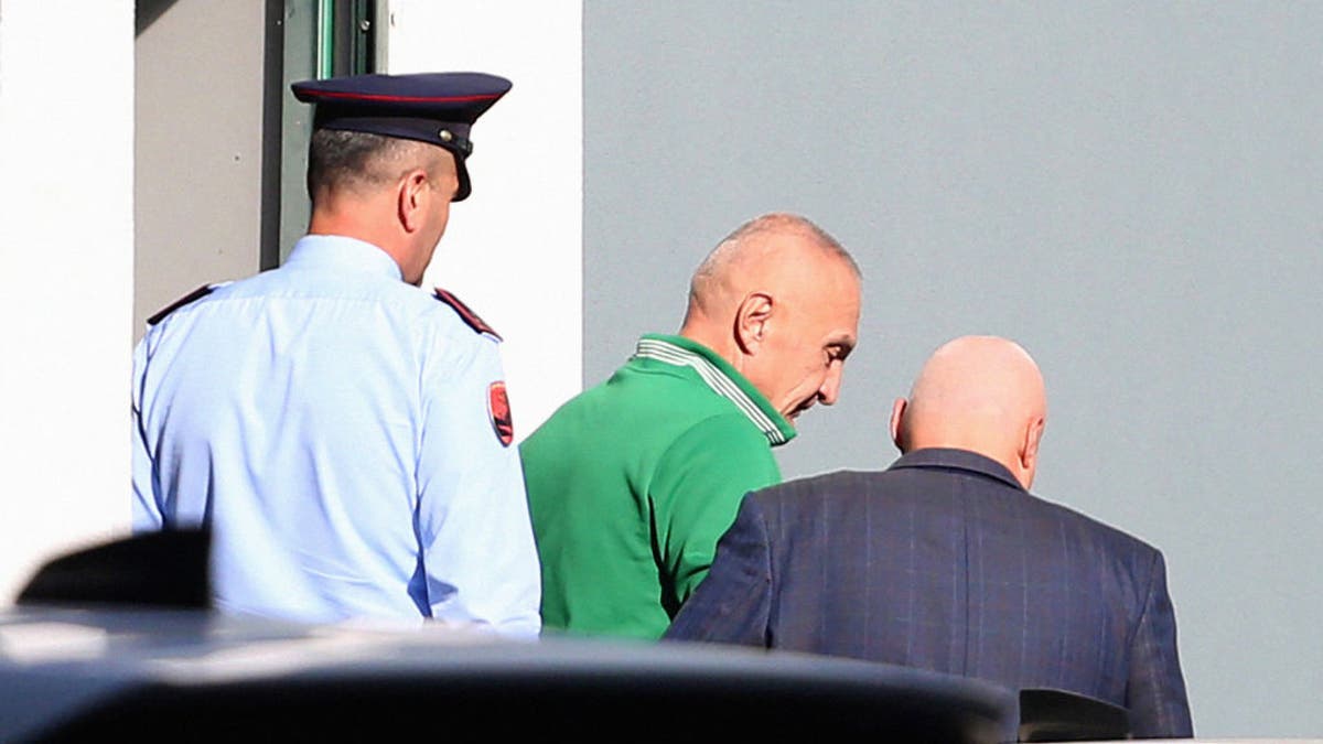 Albania's former president and curent leader of the opposition Freedom Party, Ilir Meta, center, is escorted to a police vehicle at Tirana's Police Headquarters in Tirana on Oct. 21, 2024.