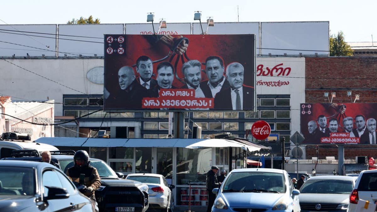 Campaign billboards of the ruling Georgian Dream Party with images of opposition party leaders and activists, reading in Georgian "No to war, no to cops" sit in Tbilisi on October 22, 2024, ahead of the October 26 parliamentary elections.