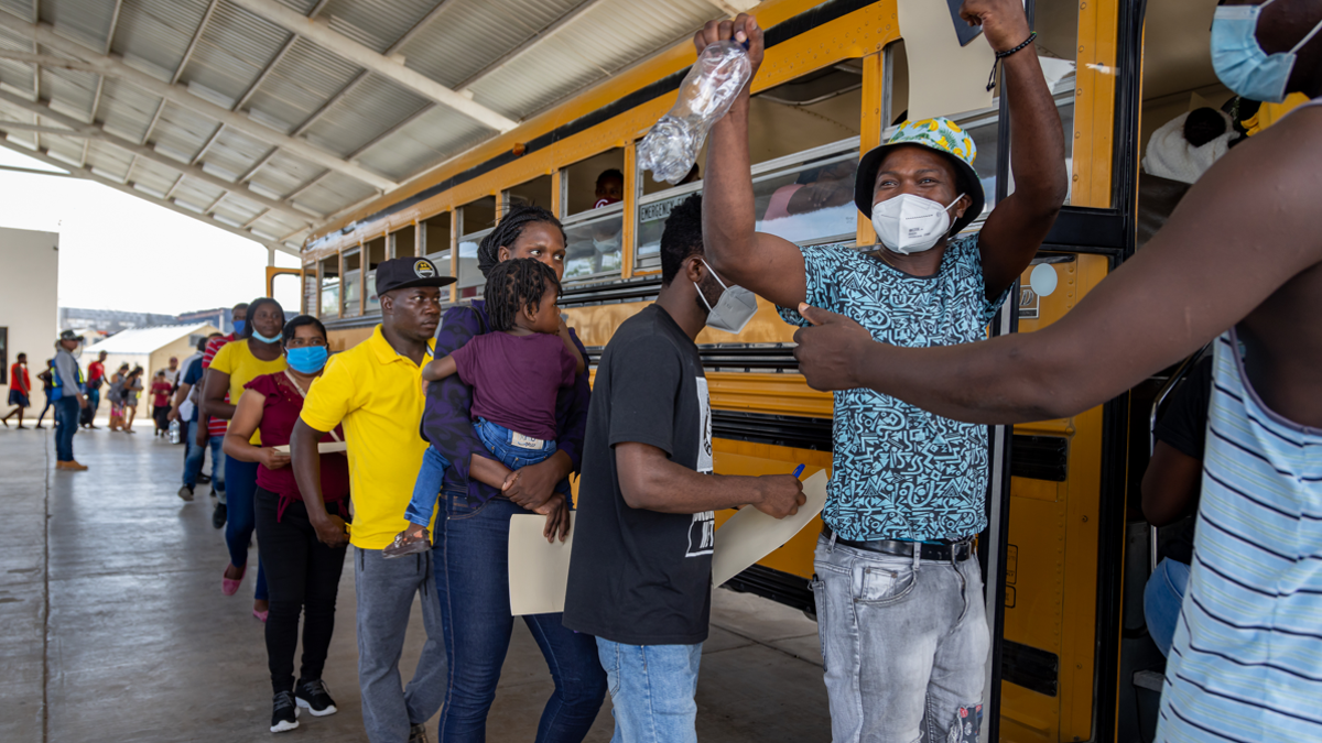 migrants board the bus