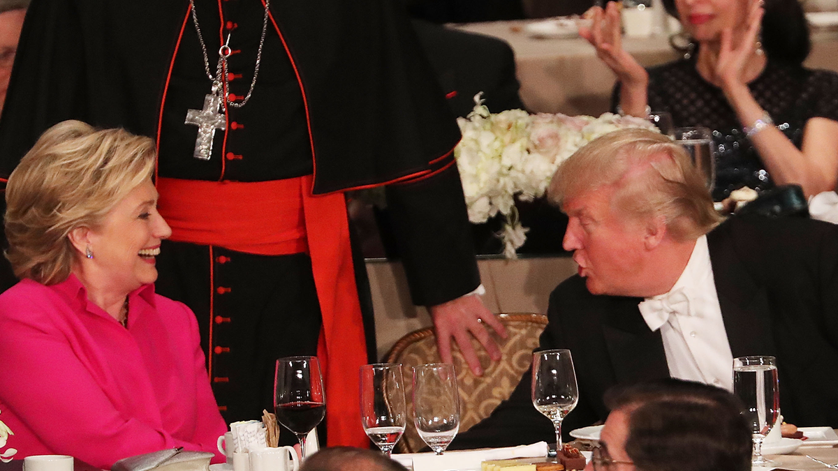 Hillary Clinton rindo enquanto Donald Trump conversa com ela no jantar de Al Smith