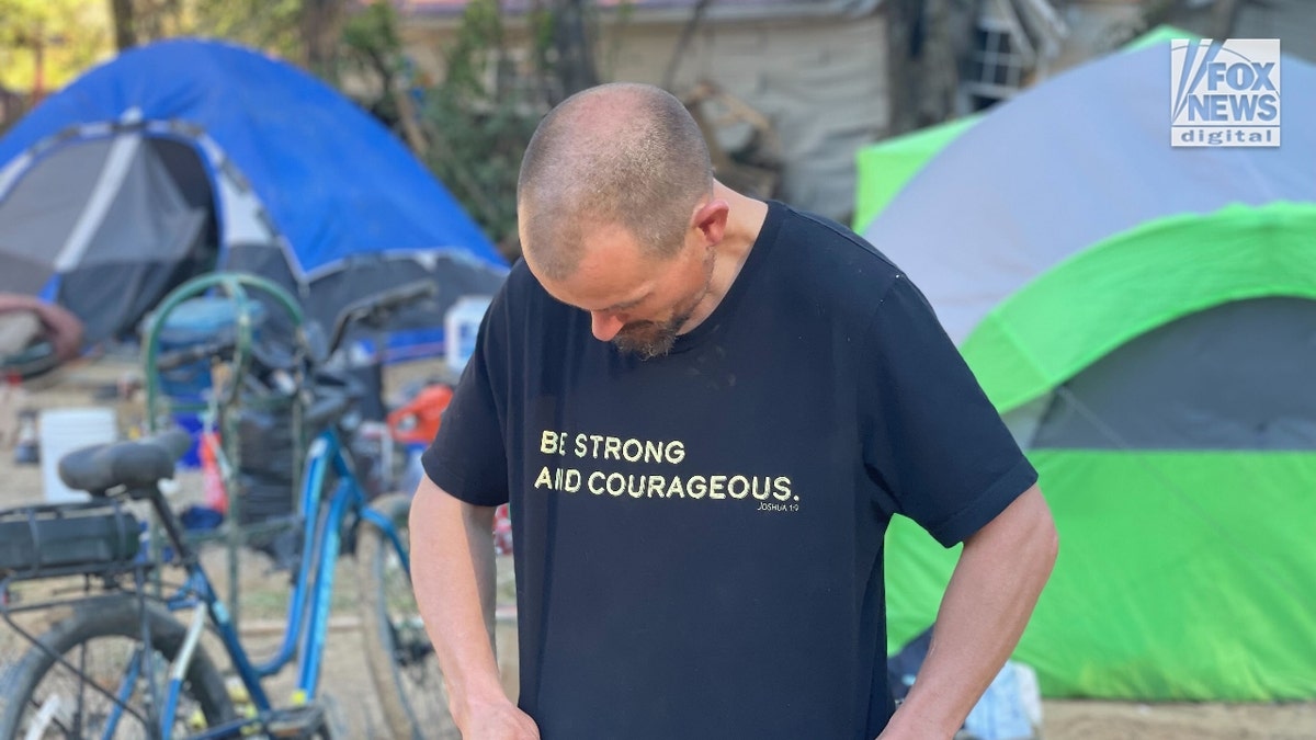 Kris Weil looks at his t-shirt, which reads, 